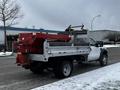 A white 2008 Ford F-450 SD truck with a flatbed and a red salt spreader attached at the back