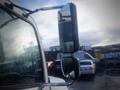 A 2013 Hino 308 truck with a focus on its side mirror showing rain droplets