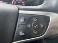 Close-up of the steering wheel control panel of a 2015 GMC Sierra 1500 featuring buttons for cruise control and audio system functions