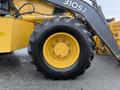 A 2011 John Deere 310SJ 4x4 Wheel Loader Extended Hoe with a yellow wheel and a rugged black tire displaying tire tread and rim details