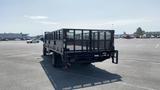 A 2019 Ford F-550 flatbed truck with a metal mesh back and dual rear wheels parked in an open area