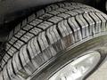 Close-up of a tire from a 2011 Ford Econoline showing pronounced tread patterns and a shiny black rim