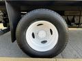 A close-up of a white wheel and tire of a 2017 Ford Econoline with a black tread pattern mounted on a steel rim