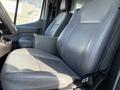 Two gray leather seats in a 2017 Ford Transit van with a center console between them