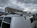 A white 2011 Ford Econoline van with a metal ladder rack mounted on the roof