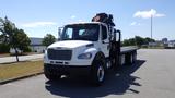 A white 2017 Freightliner M2 106 truck with a flatbed and a mounted crane on the rear