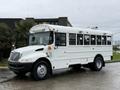 A 2016 International CE300 school bus with a white exterior large windows and lights on the roof