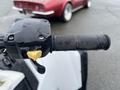 A close-up of the handlebar of a 2017 Polaris Scrambler featuring a switch labeled AWD and a textured grip on the throttle handle