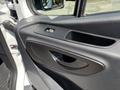 The interior door panel of a 2019 Mercedes-Benz Sprinter featuring a door handle a power window control and textured black plastic surfaces