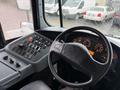 Interior view of a 2016 International CE300 bus featuring a dashboard with numerous buttons and dials along with a steering wheel and instrument cluster displays