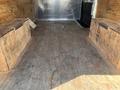 A 2012 Chevrolet Express cargo van interior with wooden flooring and side benches made of plywood