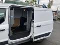 A 2017 Ford Transit Connect van with an open sliding side door revealing a spacious cargo area and racks inside