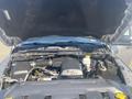 The image shows the engine compartment of a 2021 RAM 1500 with a prominently displayed 3.6L V6 engine and various engine components including hoses and coolant reservoir