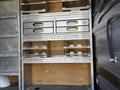 A 2010 Mercedes-Benz Sprinter with a metal shelving unit featuring multiple drawers and compartments designed for storage and organization