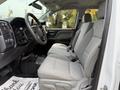 Interior view of a 2018 Chevrolet Silverado 1500 featuring two front seats with gray fabric upholstery and a dashboard with controls and a steering wheel