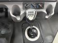 A gear shift lever of a 2016 Freightliner 108SD with buttons labeled for different gear positions and two climate control knobs above it