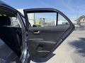A 2018 Kia Rio5 with an open front passenger door displaying the interior door panel and handle