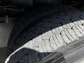 Close-up of a worn tire with deep treads, typical of a heavy vehicle, resting on a fire truck chassis