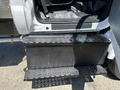 A close-up view of a black perforated step on a 2019 Ford F-750 truck providing access to the vehicle's interior