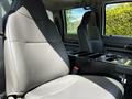 A gray cloth seat in a 2009 Ford F-550 with a central console featuring various controls and storage compartments