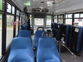 Interior view of a 2020 Chevrolet Express showing blue upholstered seats arranged in rows without any passengers