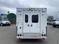 A rear view of a 2014 Chevrolet Express with a white exterior featuring two large doors and multiple lights on the top edge