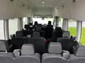 Interior view of a 2021 Ford Transit showing multiple rows of black seats with headrests and a dashboard visible in the front