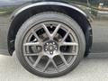 Close-up of a black alloy wheel from a 2017 Dodge Challenger featuring a multi-spoke design and a performance tire