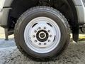 Close-up of a white wheel with black accents and a rugged tire of a 2024 Ford F-550