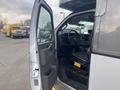 A 2016 Chevrolet Express van with an open driver's side door showing a black seat and dashboard with steering wheel and control buttons