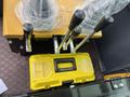 A control panel with multiple levers and a yellow toolbox labeled TOOLS BOX placed on a textured surface