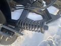 A close-up view of a spring mounted on a 2000 plow attachment designed for snow removal with a 12-foot width