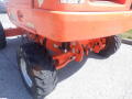 A 2008 JLG Boom Lift featuring large rubber tires and an orange exterior with visible wear and tear on the body
