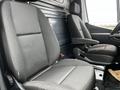 Two front seats of a 2021 Mercedes-Benz Sprinter van featuring fabric upholstery and adjustable headrests