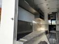 Interior of a 2017 Freightliner M Line featuring metal shelving and a diamond plate floor with seating area along one side