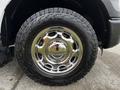 Close-up of a chrome wheel with a shiny rim and rugged tire tread featuring a thick tire designed for off-road use