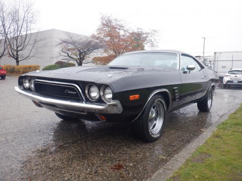 A 1974 Dodge Challenger in black with chrome accents and a sleek design, showcasing its iconic front grille and sporty profile