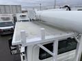 A 2007 International 4200 truck with a mounted white utility basket on the roof and a flat metallic surface visible