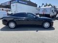 A black 2019 Dodge Charger is shown from the side with sleek lines and distinctive features including round headlights and five-spoke alloy wheels