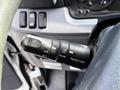 Close-up of a 2015 Mitsubishi Fuso FE steering wheel control lever featuring buttons for cruise control functions like cancel off set and resume