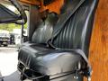 Black leather driver's seat with a seatbelt in a vehicle interior designed for work purposes
