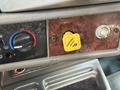 Close-up of a control panel in a 2009 Kenworth T270 featuring a yellow parking brake release button and various knobs for climate and system controls
