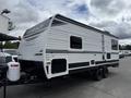 A 2022 Keystone Hideout RDWE 20RDWE travel trailer with a sleek silver and black exterior and multiple windows on the side