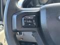Steering wheel control panel of a 2016 Ford F-150 featuring directional buttons and an OK button