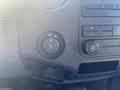 The image shows the dashboard controls of a 2014 Ford F-250 SD including a knob for power settings and climate control buttons