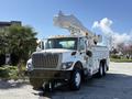 A white 2008 International 7500 bucket truck with a raised boom and utility storage compartments on the sides
