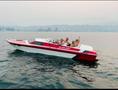 A 1989 Nordic Viking boat in red and white with four people onboard enjoying the water and raising their hands in celebration