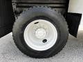 Close-up of a white wheel with a silver rim and a large black tire mounted on a 2012 Freightliner M2 106