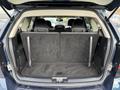 A 2013 Dodge Journey with its rear seats folded down showing a spacious cargo area with a gray carpeted floor and black interior trim