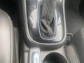 The gear shift console of a 2018 Buick Encore featuring a black leather boot and gear selection markings for park reverse neutral drive and manual modes